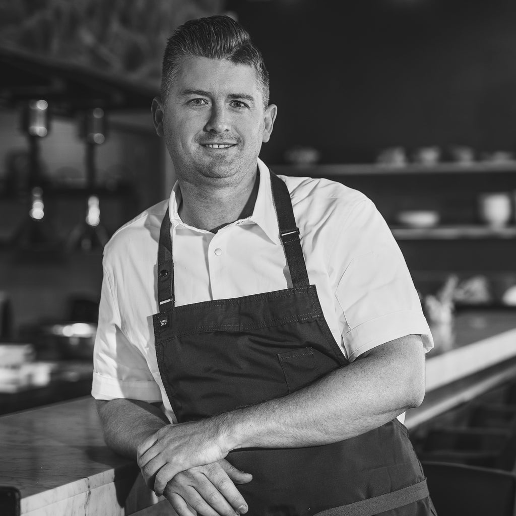 A black and white photo of Culinary Director Jed Gerrad, who manages The Restaurant's talented team at Wills Domain.